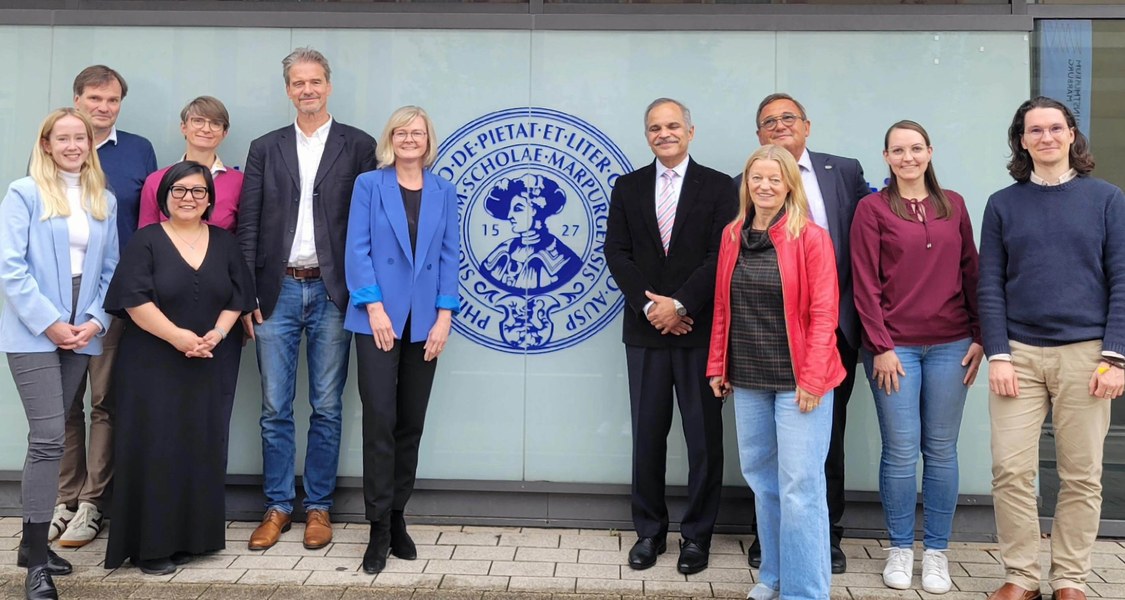 Menschen vor dem Hauptgebäude der Uni Marburg mit Philipp-Logo