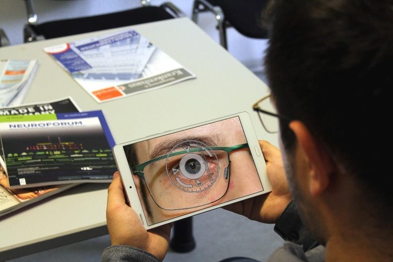 A test subject uses a tablet computer to measure eye movements in the waiting room.